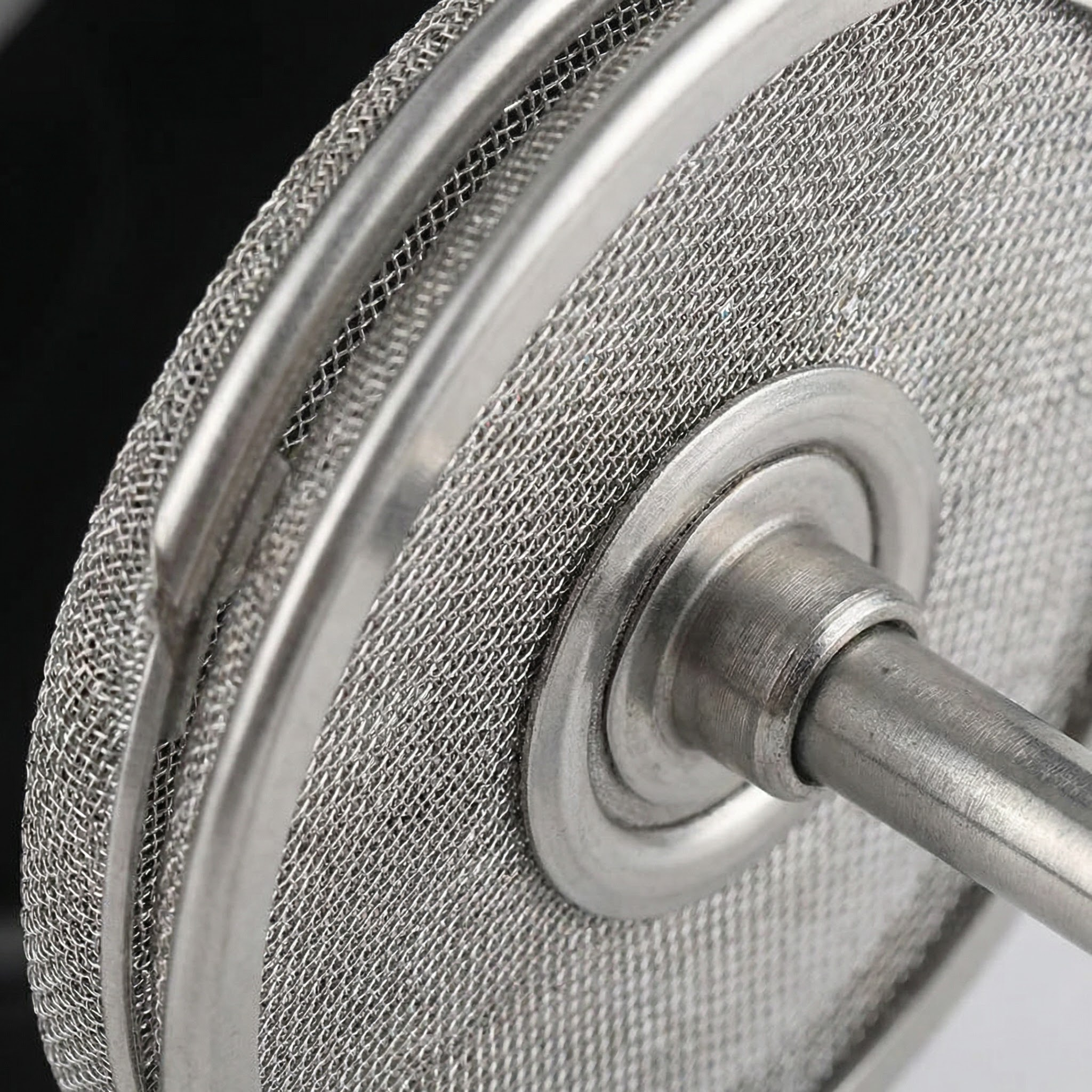 Close-up of stainless steel double mesh filter on manual milk frother – precision foam texture for cappuccino and latte